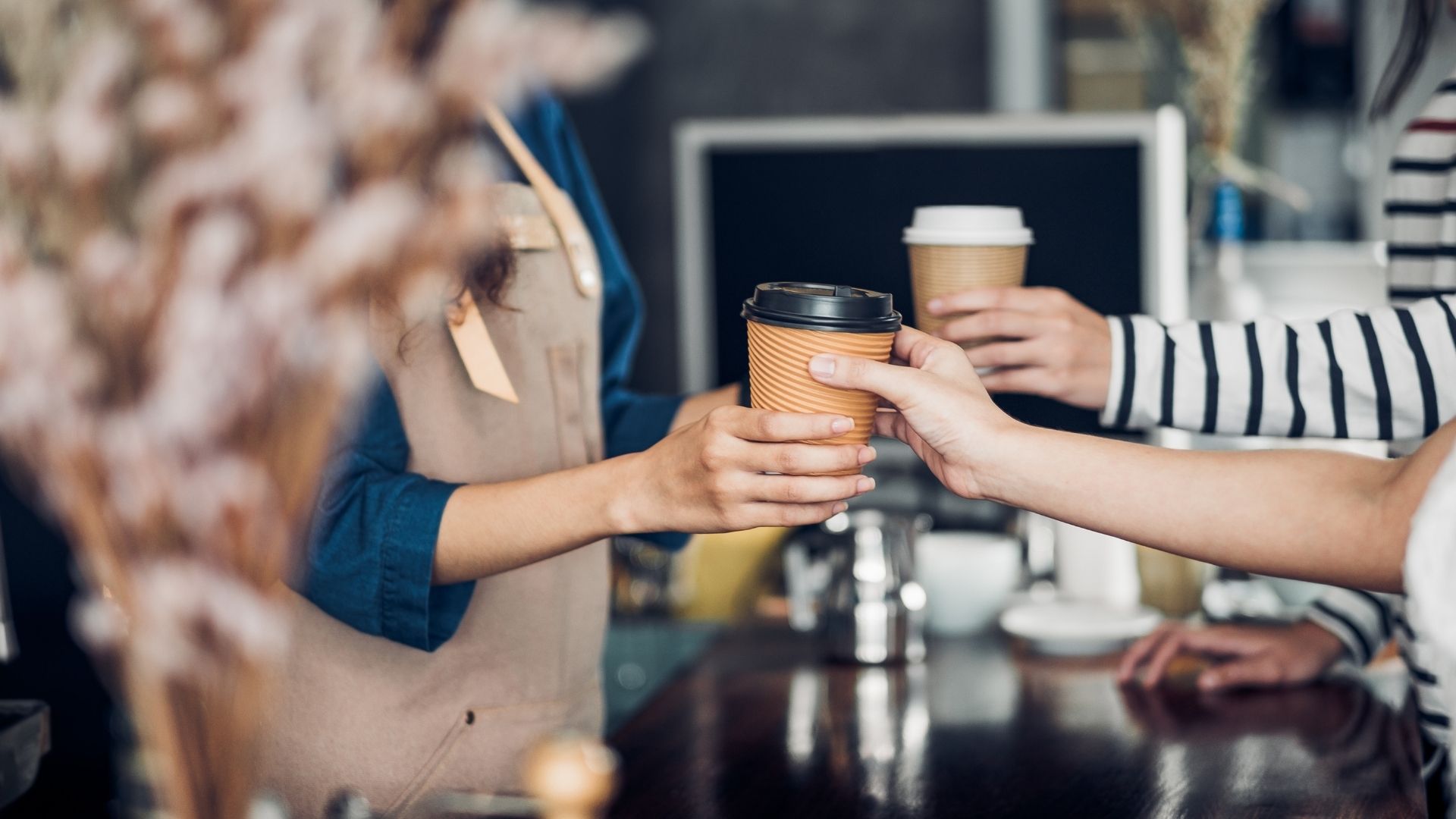 Barista handing coffee to customer
