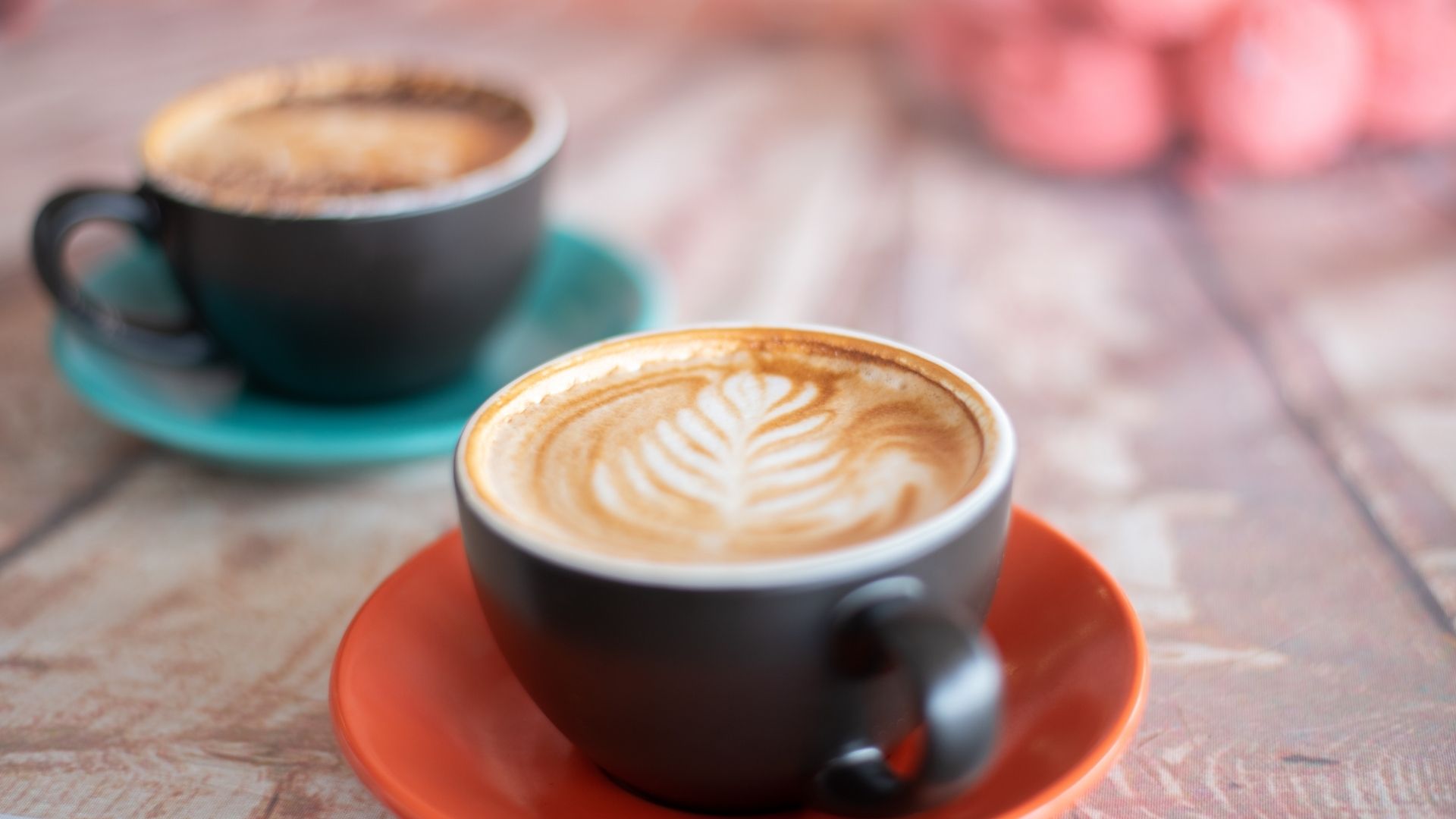 Two artistic lattes on table